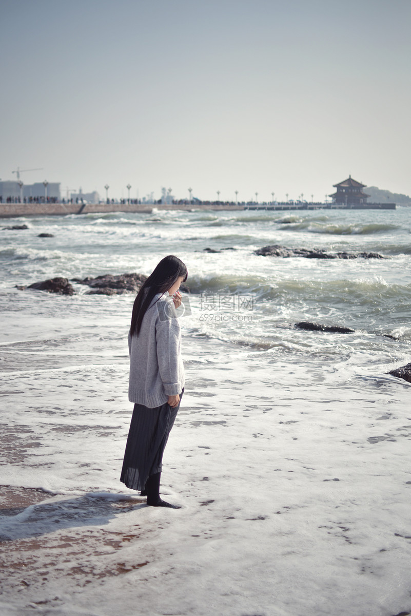 青岛海边女生浪花中的思考