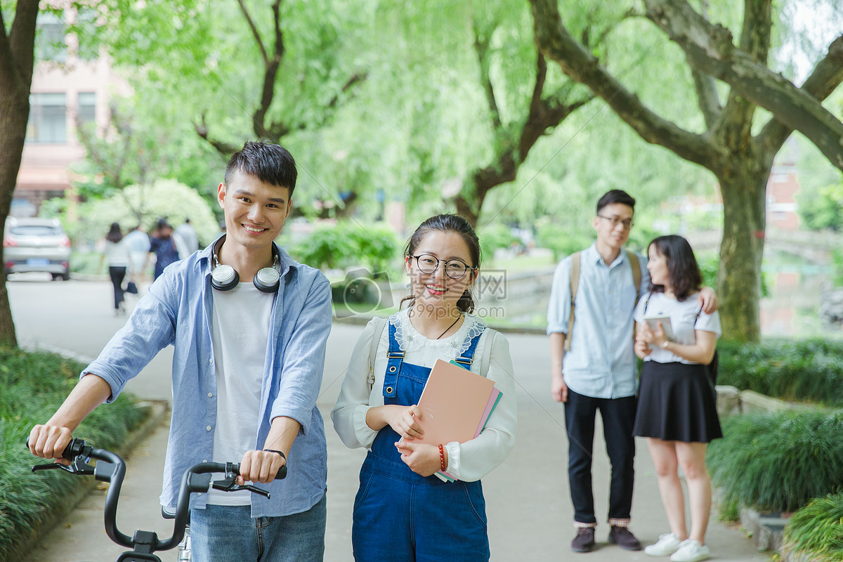 青春大学生推自行车散步聊天