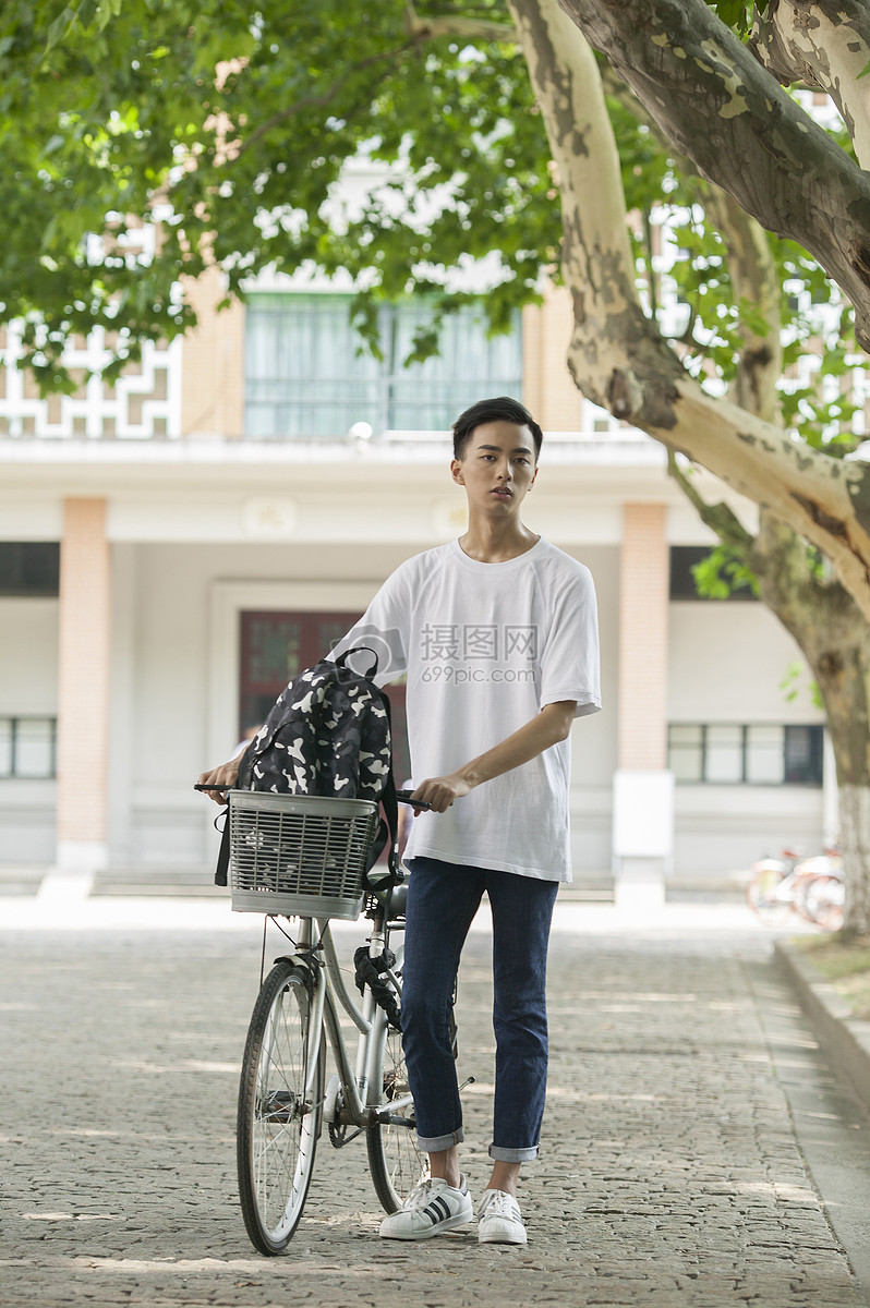 学校教室前的林荫小道上男同学推自行车