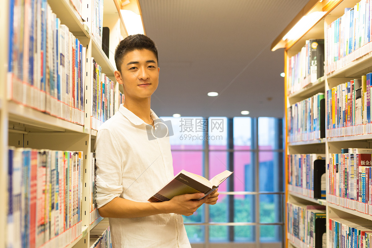 站在图书馆书架旁看书的帅气男同学