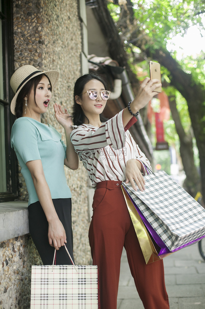女性闺蜜在小资街道购物逛街
