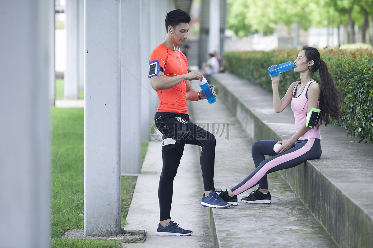 年轻男女在户外锻炼后休息喝水