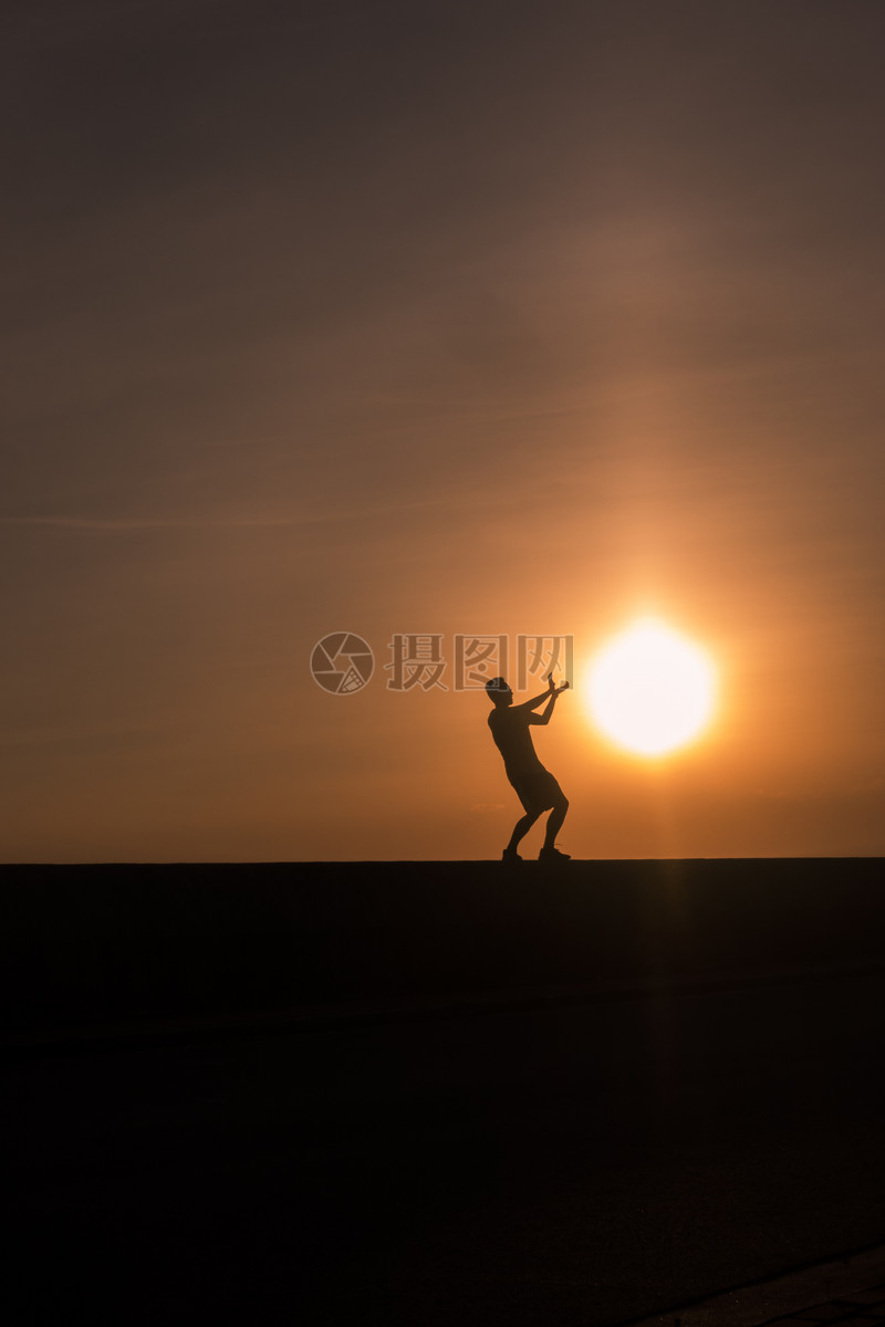 夕阳下男孩和太阳在做游戏