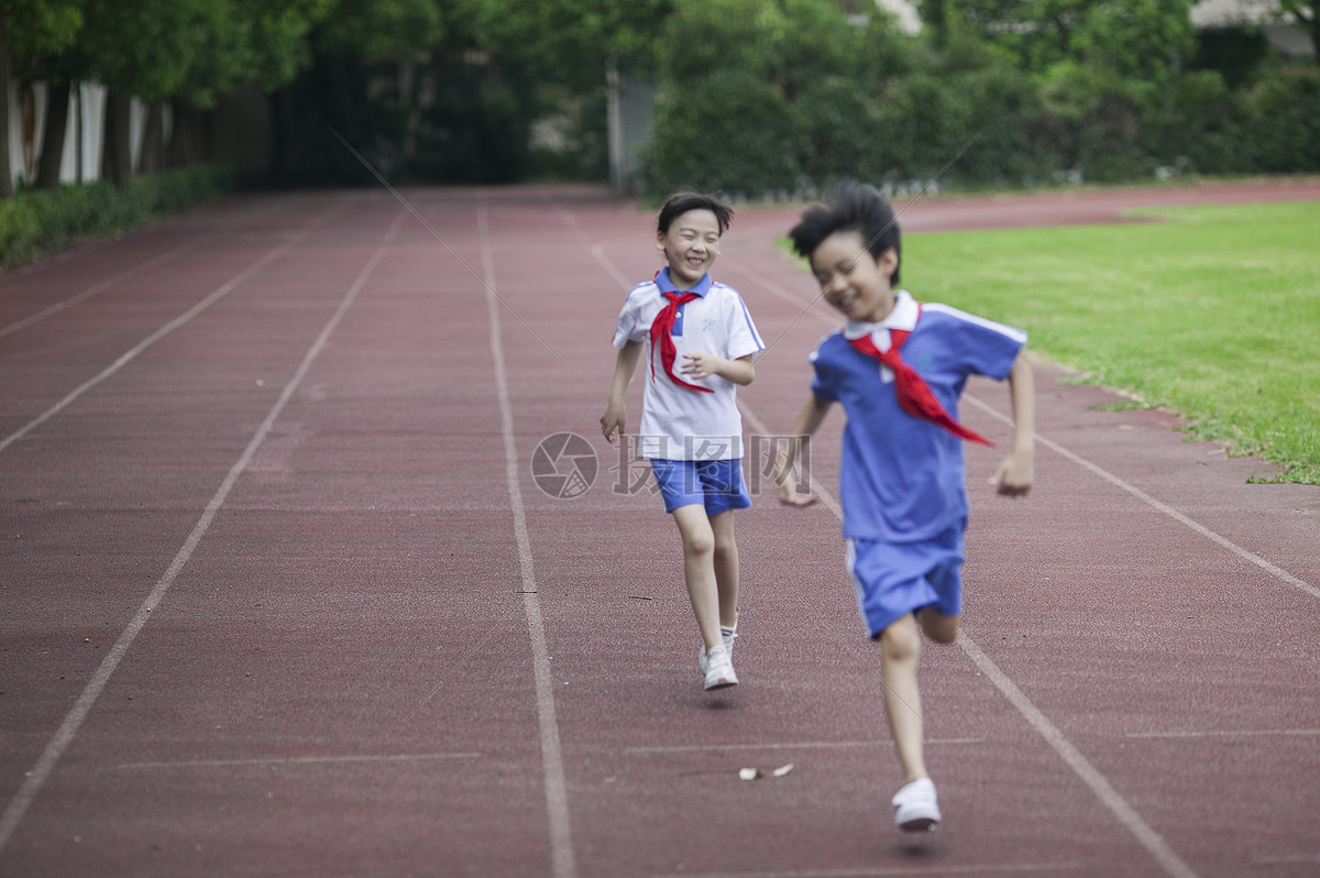 男女同学在操场跑道上比赛跑步