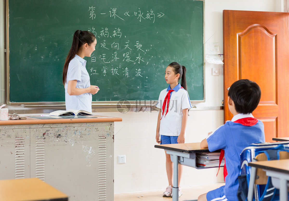 站在教室黑板前思考问题的小学生