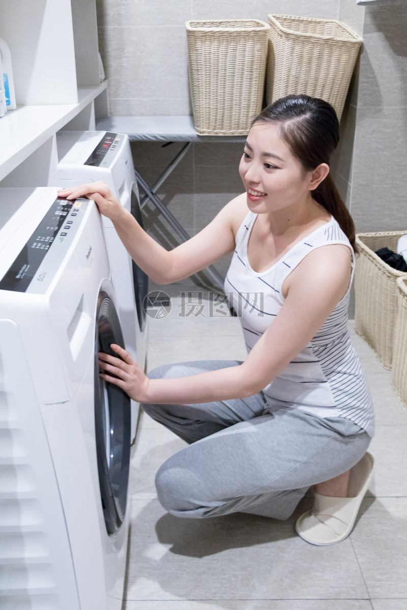 照片 生活方式 使用洗衣机洗衣服的家庭女性.