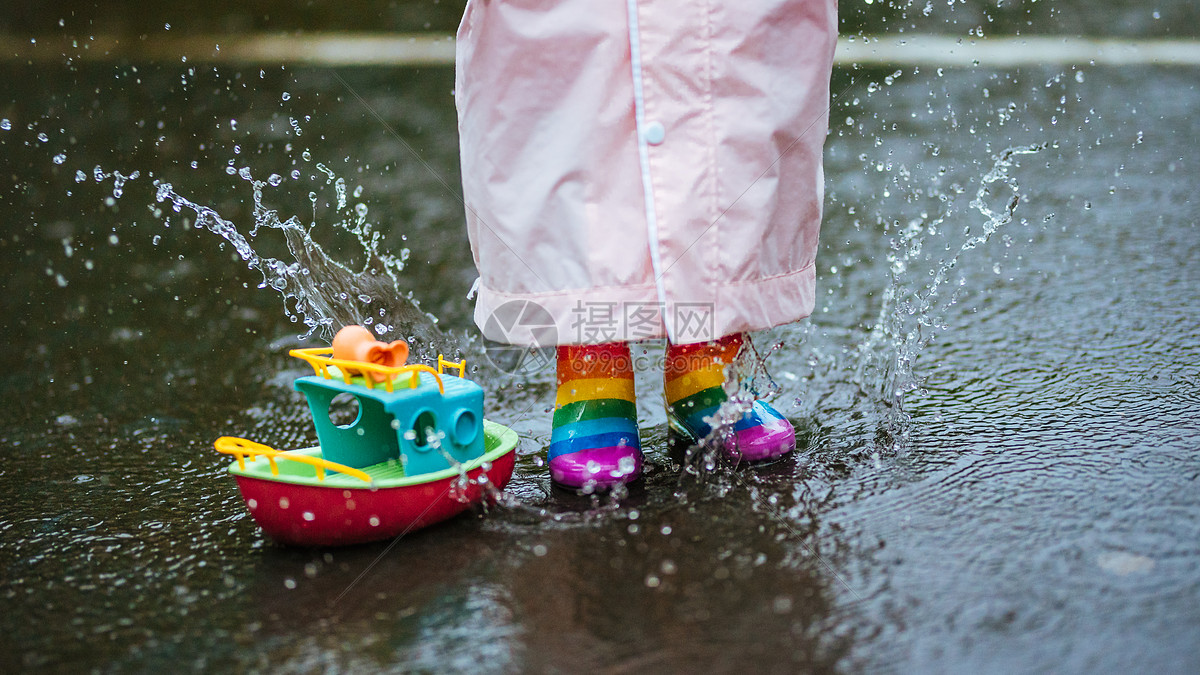 下雨天穿雨鞋的小朋友玩水