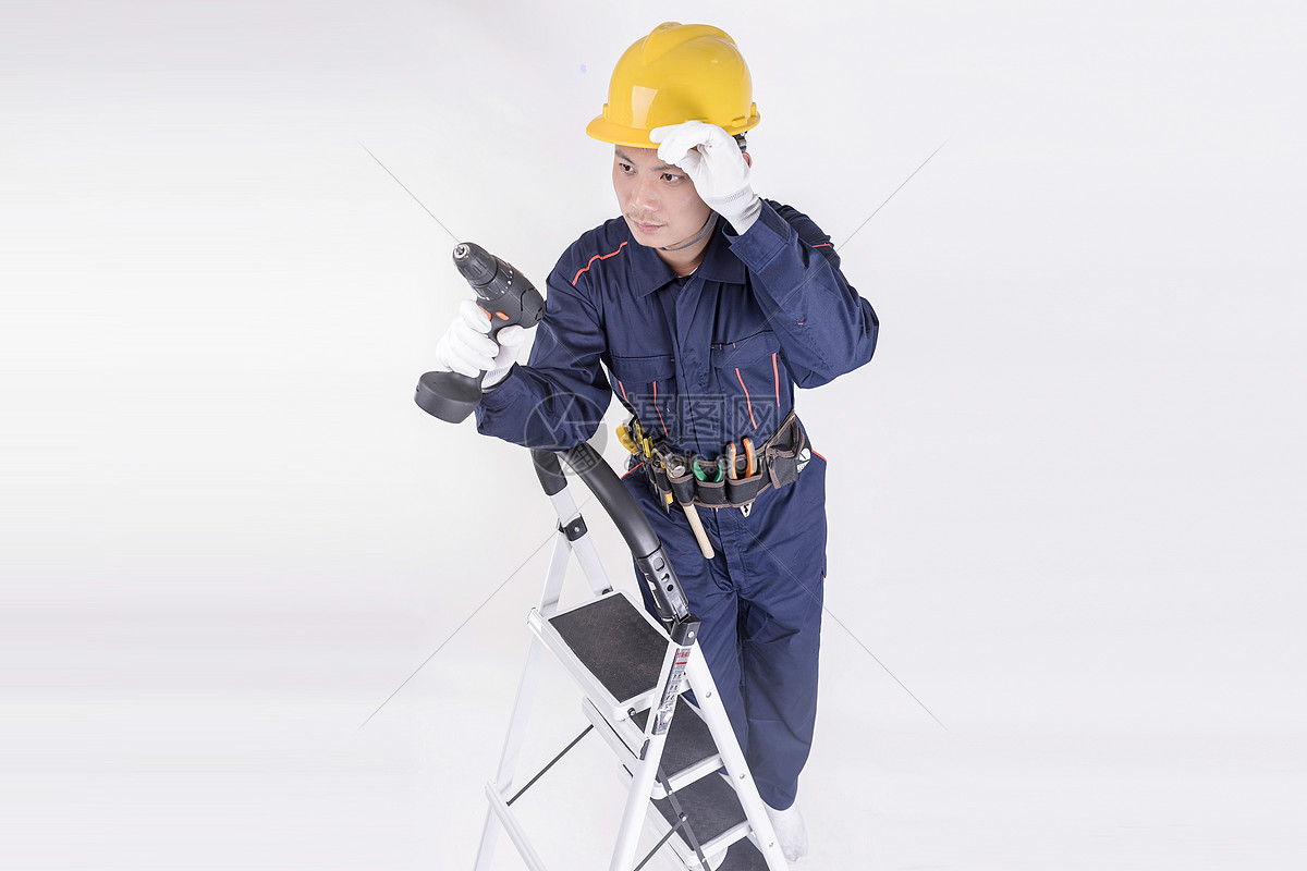 男工人爬上梯子使用工具