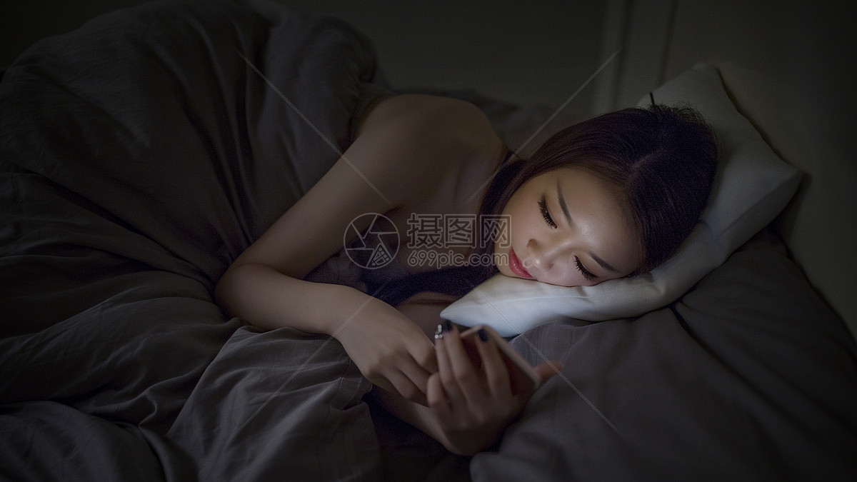 深夜睡前躺着玩手机的女生
