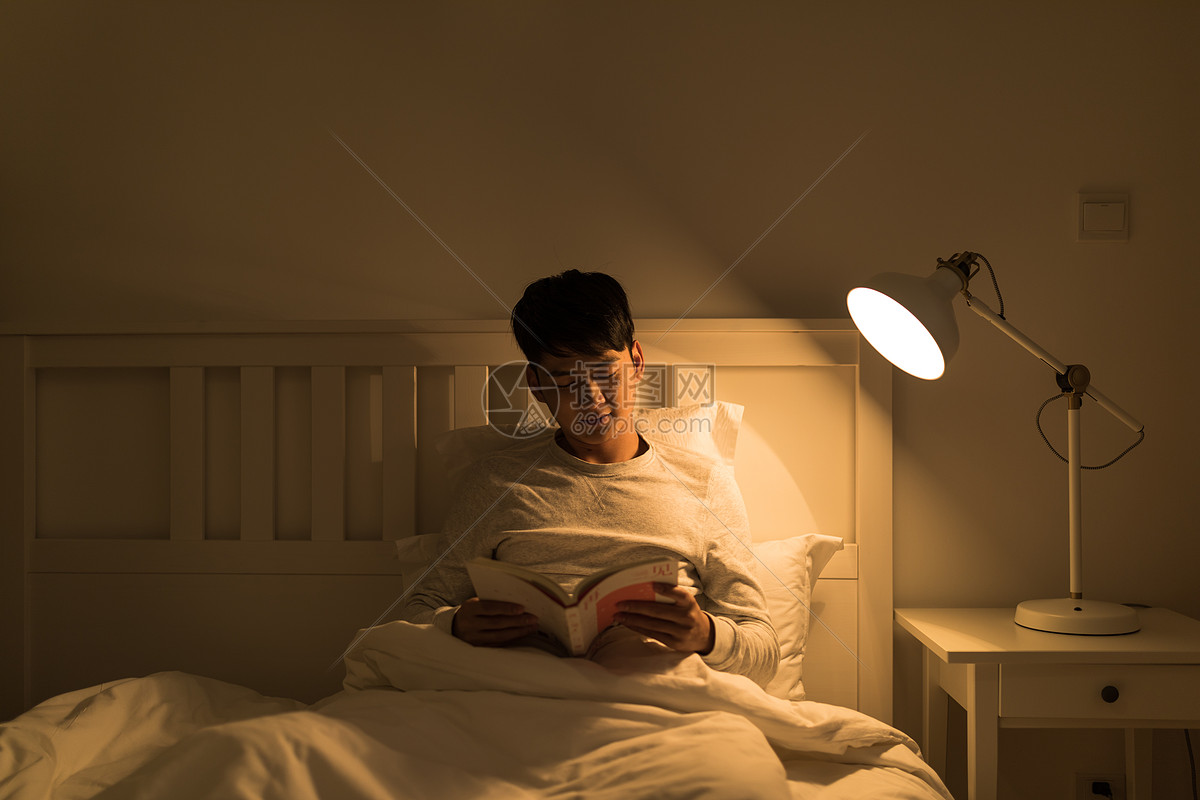 睡前坐在床上看书的男生