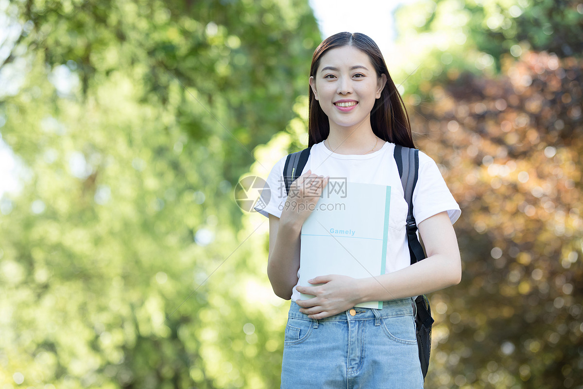 背着书包走在校园里的大学生图片