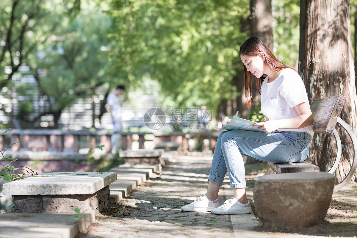坐在树下看书的女生