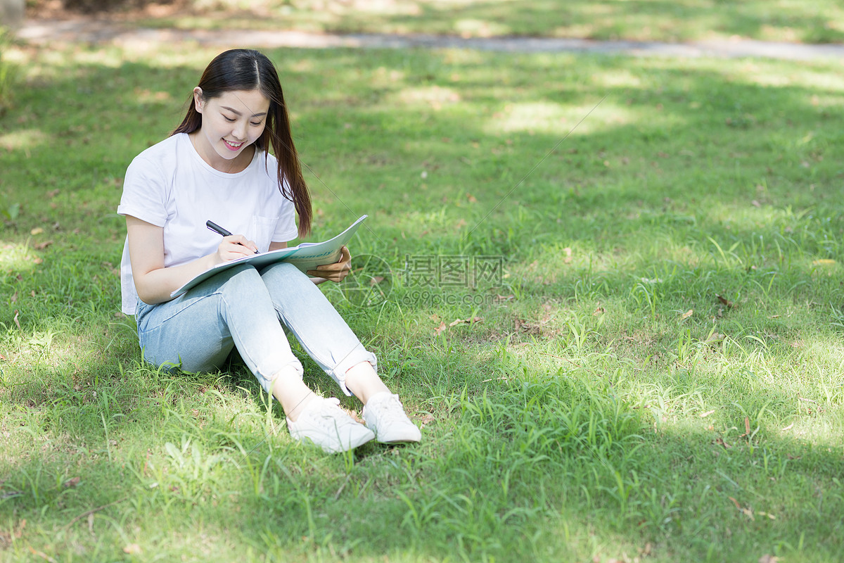草地草坪坐在校园草坪上看书学习的同学图片坐在校园草坪上看书学习的