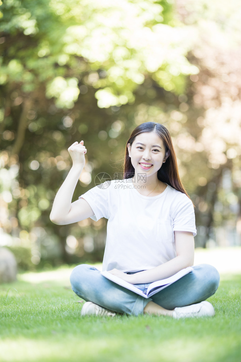 愉快地坐在草坪上学习的女同学