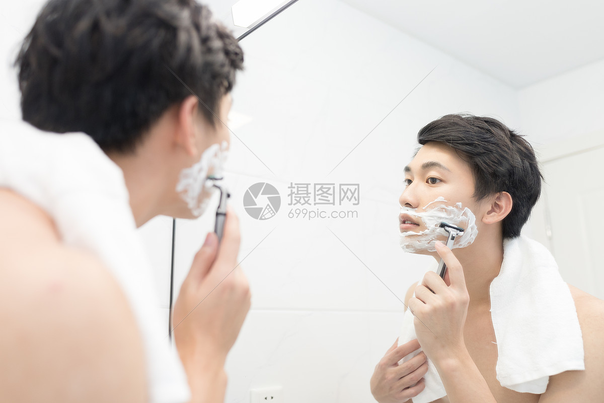 年轻男性照镜子刮胡子
