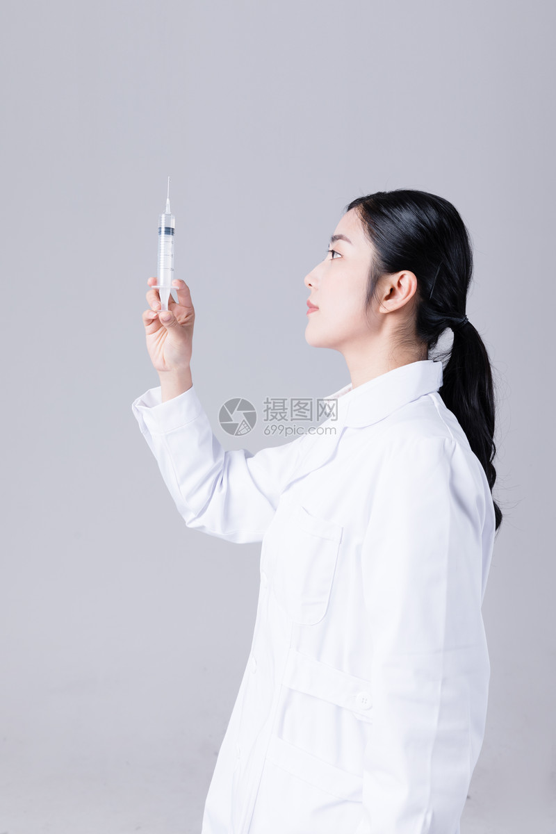 年轻女医生手拿针管