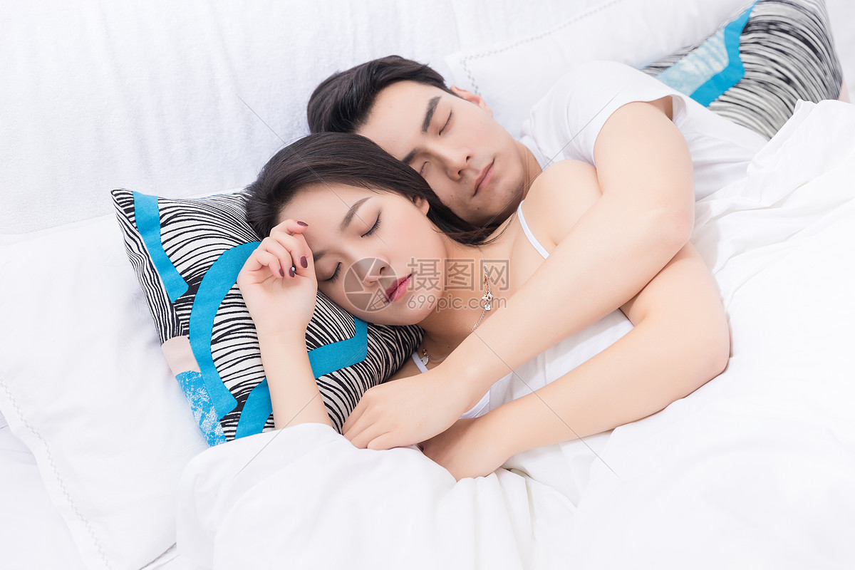 年轻夫妻拥抱躺床上休息