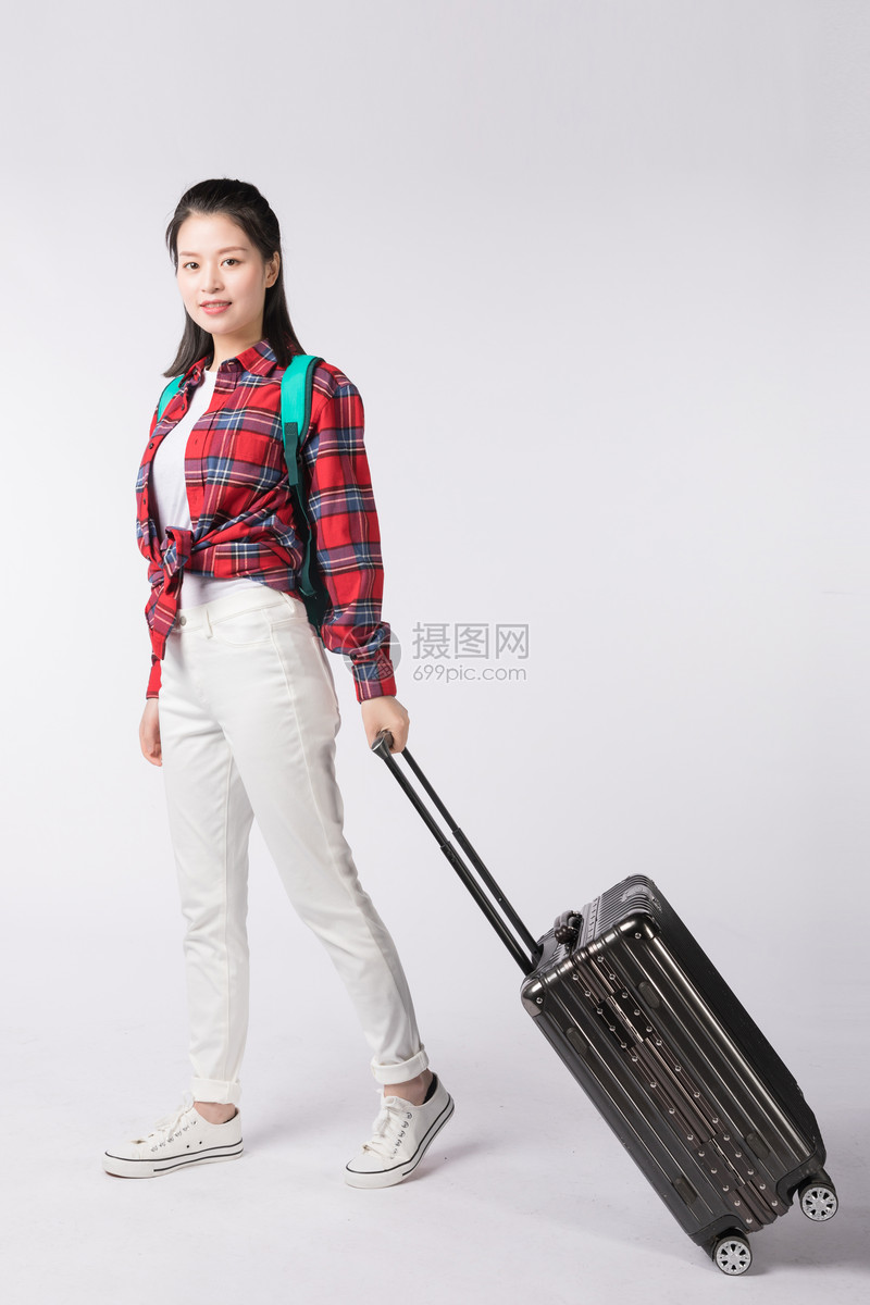 背着书包拉着行李箱的年轻女性
