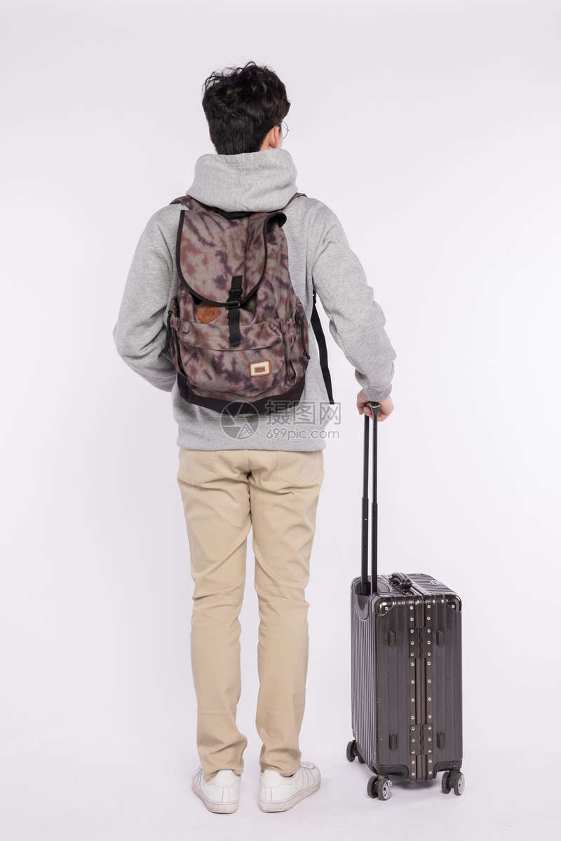 拉着行李箱背着书包的男生背影