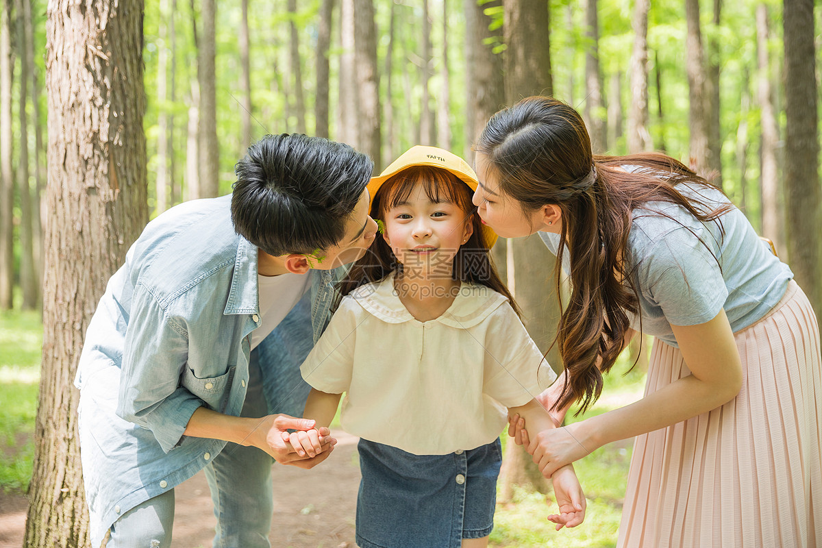 照片 人物情感 一家三口 公园森林里父母亲吻孩子.jpg