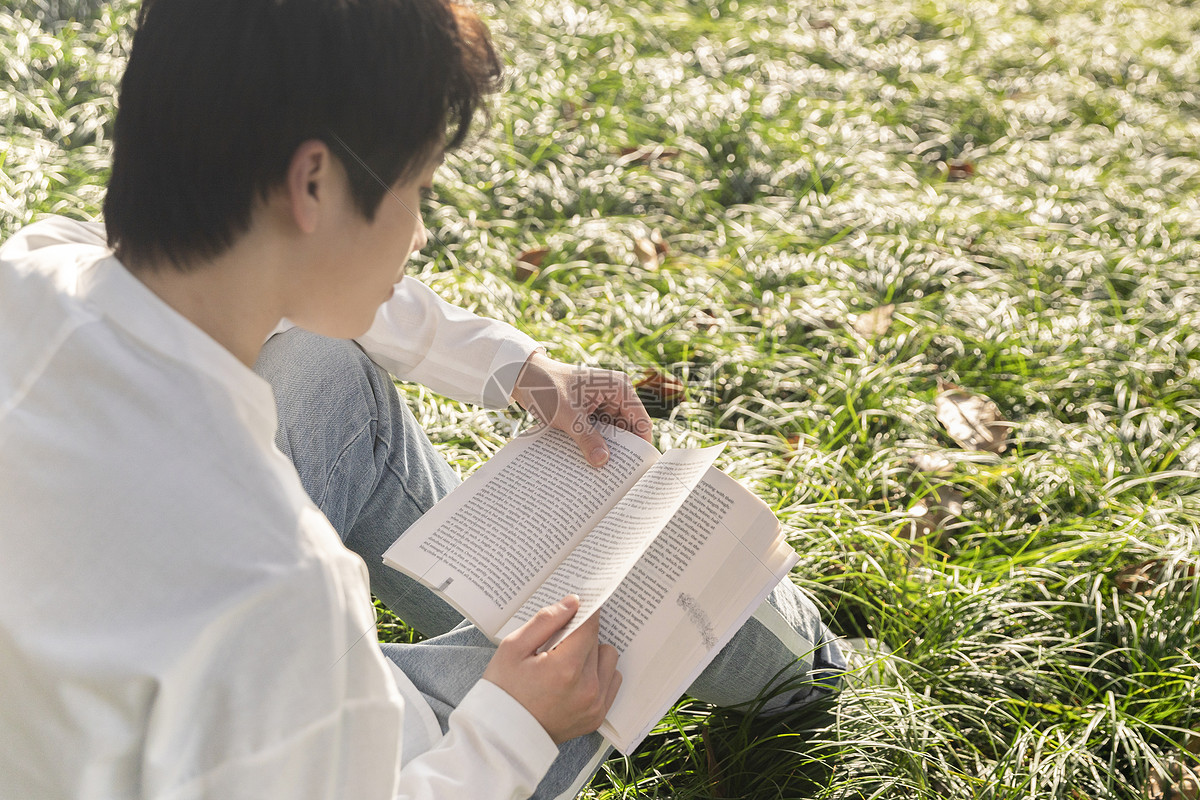照片 教育文化 在草坪上看书的男生.