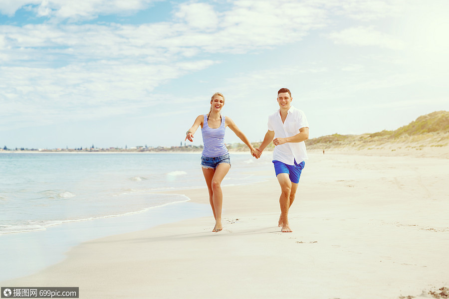 浪漫的轻夫妇海滩上浪漫的轻夫妇海滩上沿着海岸奔跑幸福的美丽的