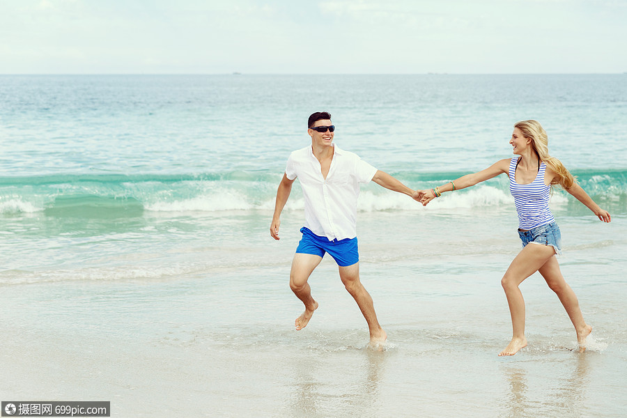浪漫的轻夫妇海滩上浪漫的轻夫妇海滩上沿着海岸奔跑女的放松