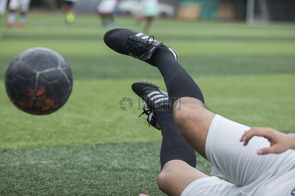 足球运动员在草坪上训练踢球