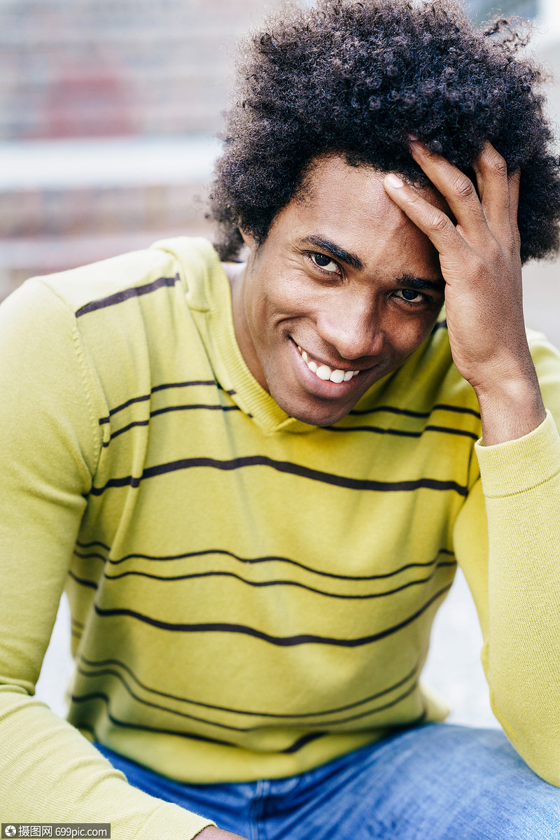 古巴黑人游客,留着afro的头发,坐地板上微笑着拍照古巴黑人游客,留着