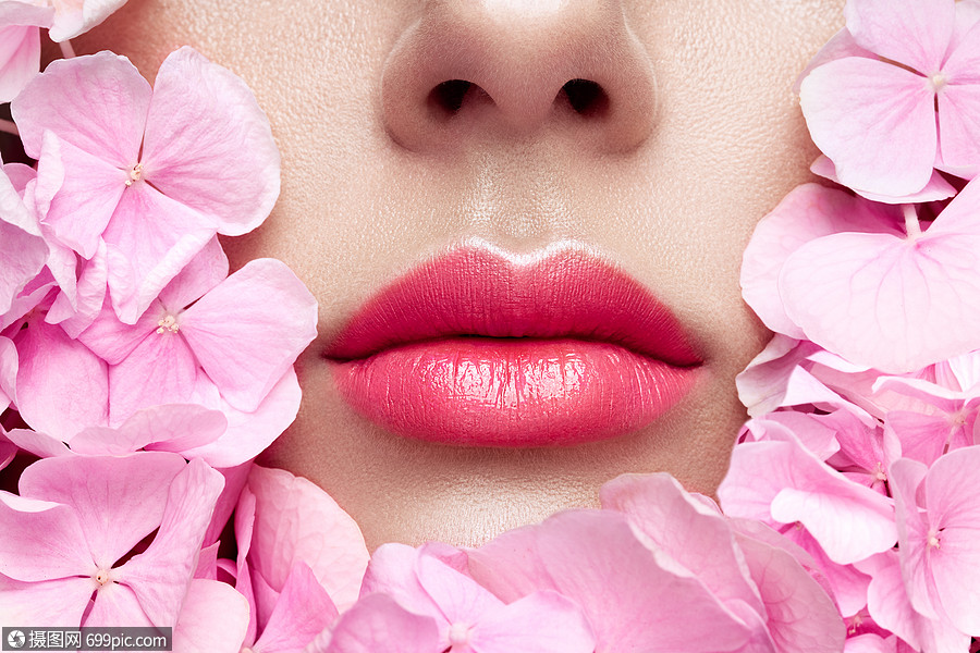 近距离观看美丽的女人嘴唇与粉红色口红花美容,药店或时尚化妆模特面