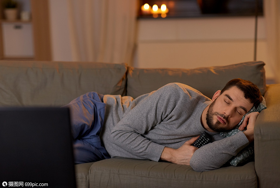 休闲人的男人睡沙发上,电视遥控器家里晚上男人睡沙发上,家里有电视