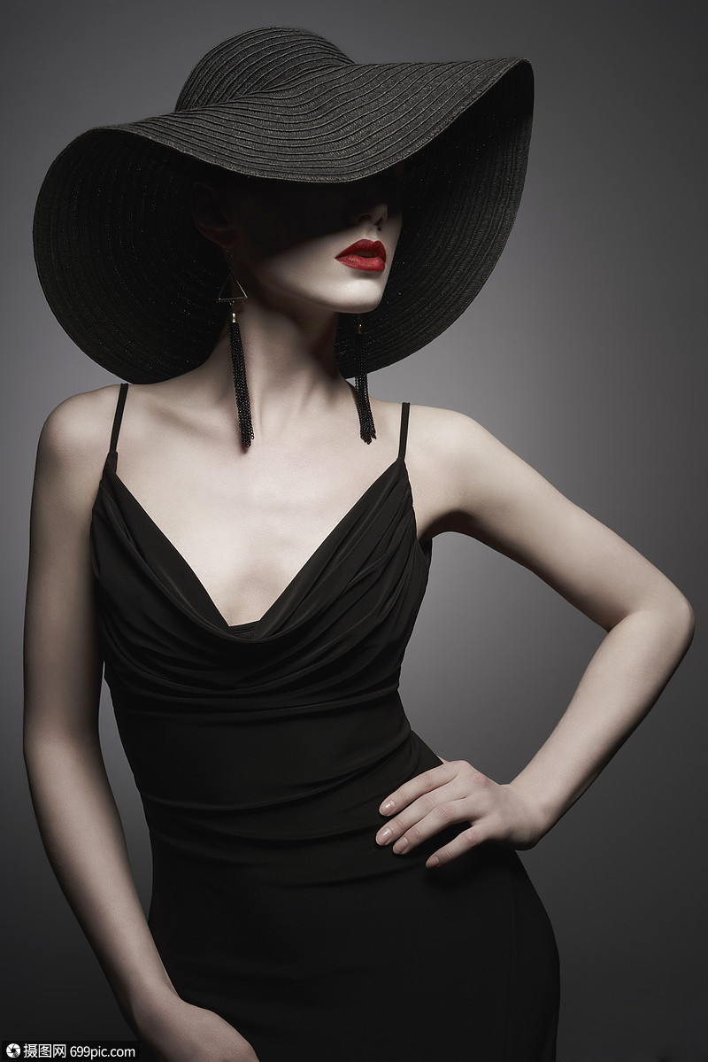 黑色帽子晚礼服时尚优雅的女人与现代珠宝灰色背景上漂亮模特的工作室