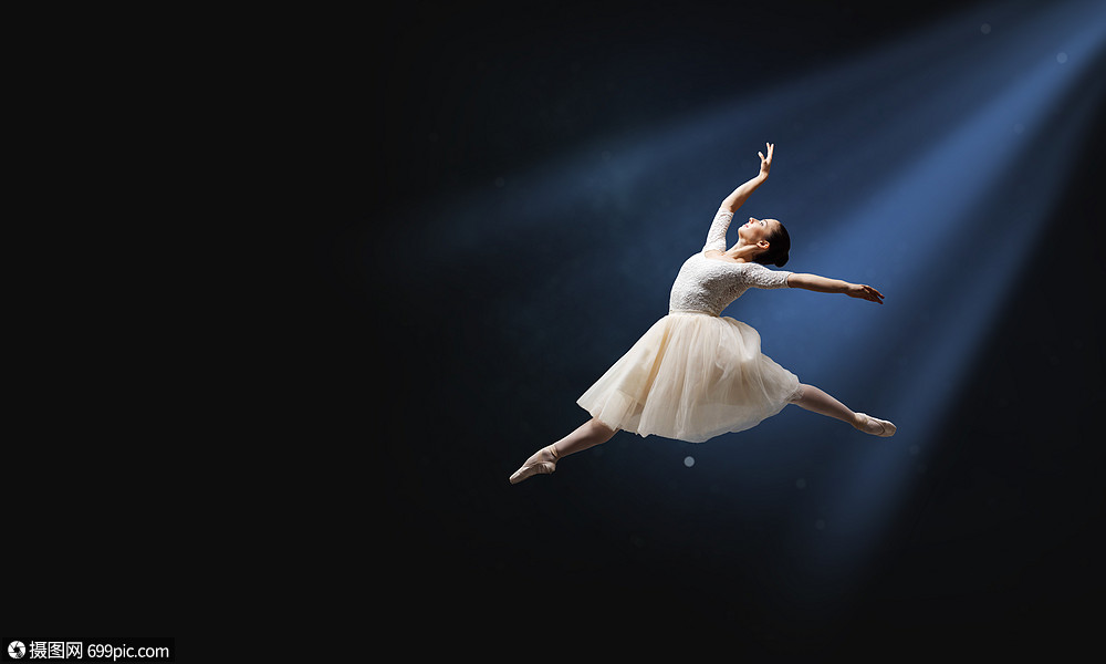 优雅的女舞者穿着白色的连衣裙,黑暗的背景下跳芭蕾的舞者