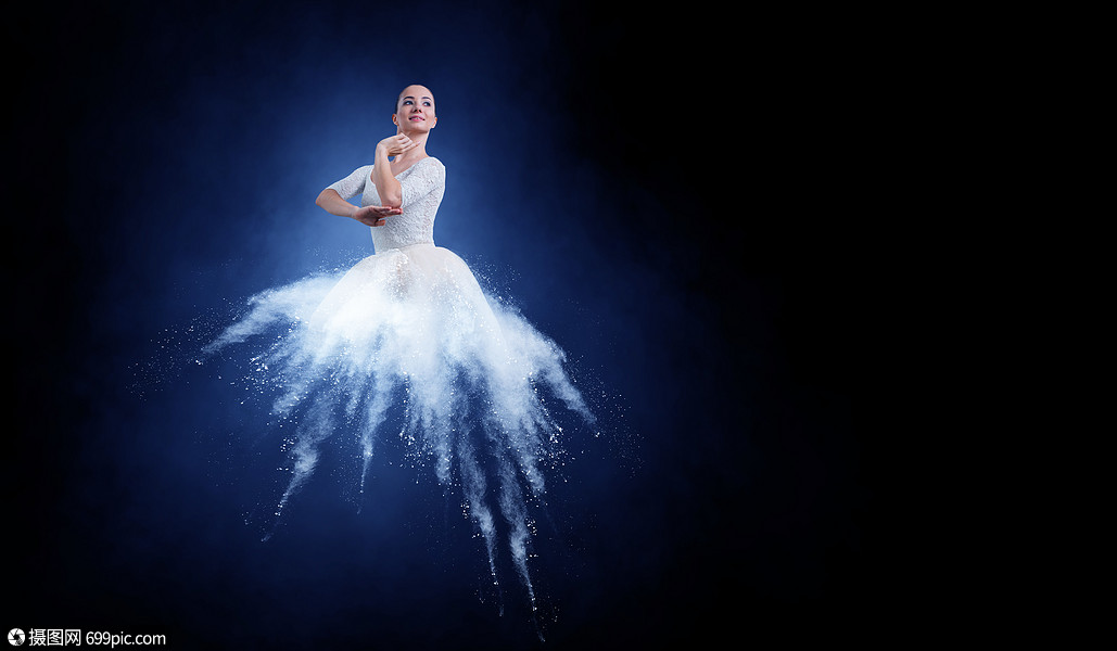 优雅的女舞者穿着白色的连衣裙,黑暗的背景下跳芭蕾的舞者艺术令人