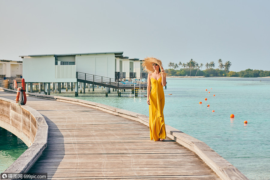 照片 外国人像 穿着连衣裙的女人走热带海滩的木板路上马尔代夫的暑假