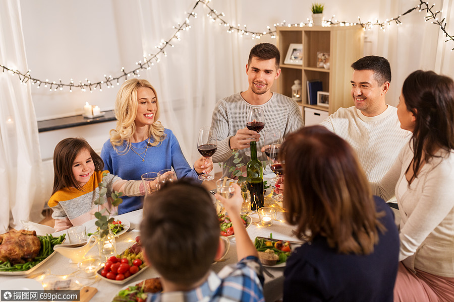 人们的快乐的家庭吃晚餐聚会,喝红酒家品尝幸福的家庭家里举行晚宴