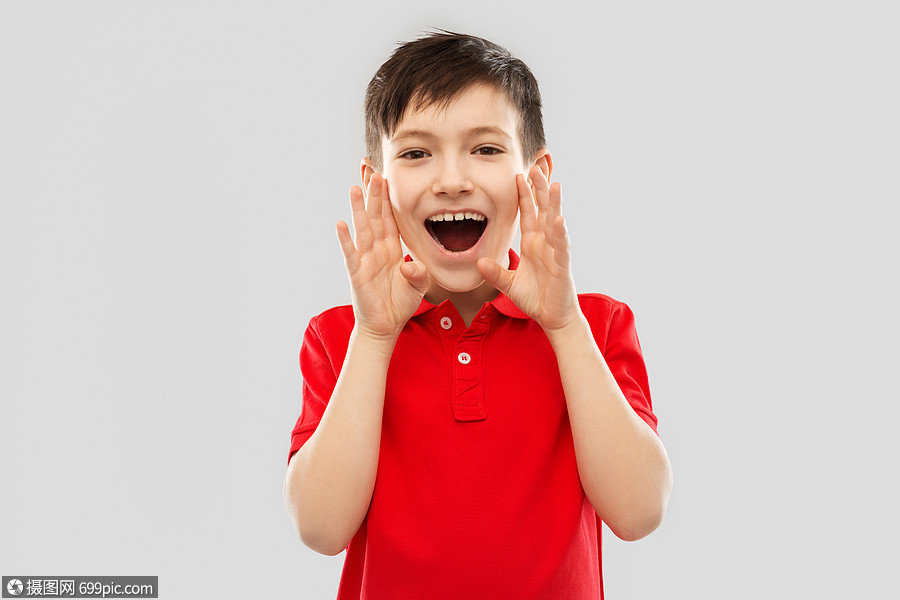 童,表情人的快乐的小男孩穿着红色马球t恤,灰色背景上大喊大叫打电话
