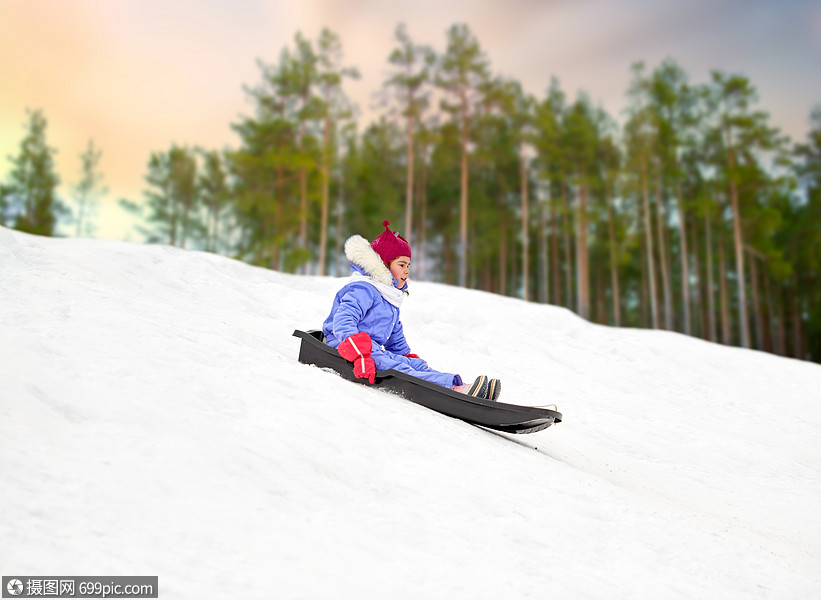冬天雪山上滑雪橇的小女孩骑轻的