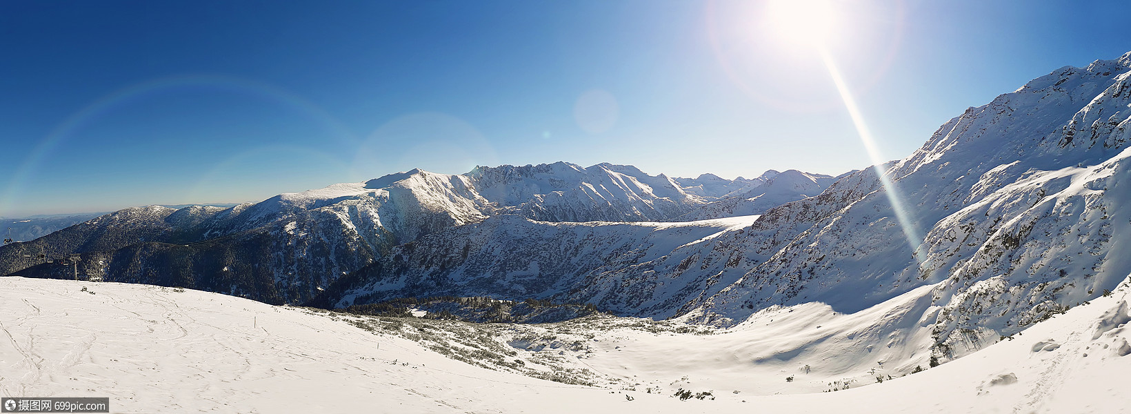 阳光明媚的冬日全景雪山的顶部