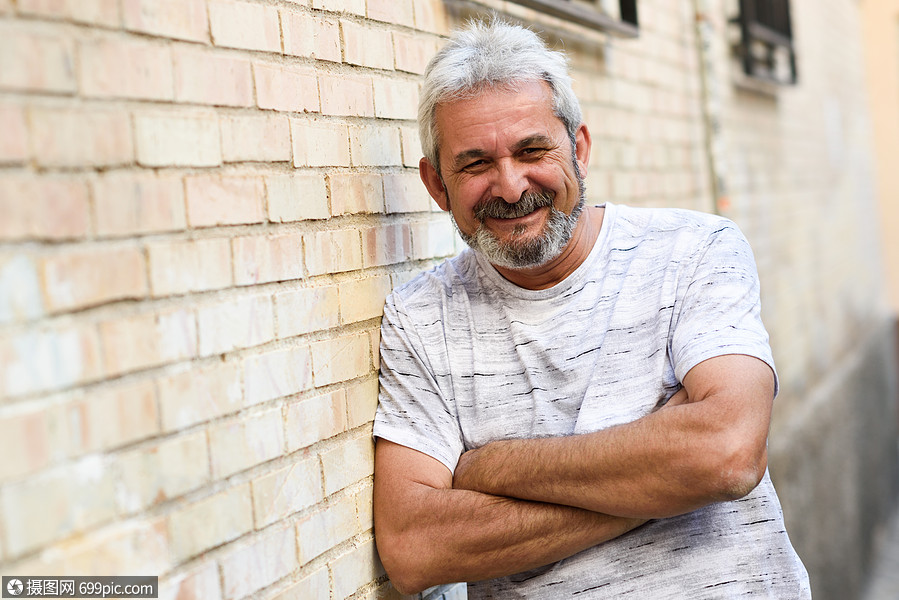 成熟的男人城市背景下着相机微笑白发胡须的老男穿着休闲服装