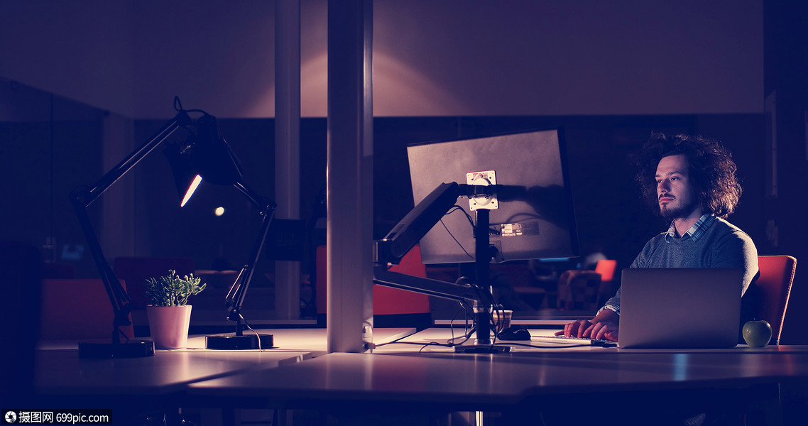 晚上黑暗的办公室里用电脑工作的轻人师稍后的时间工作聪明的轻的
