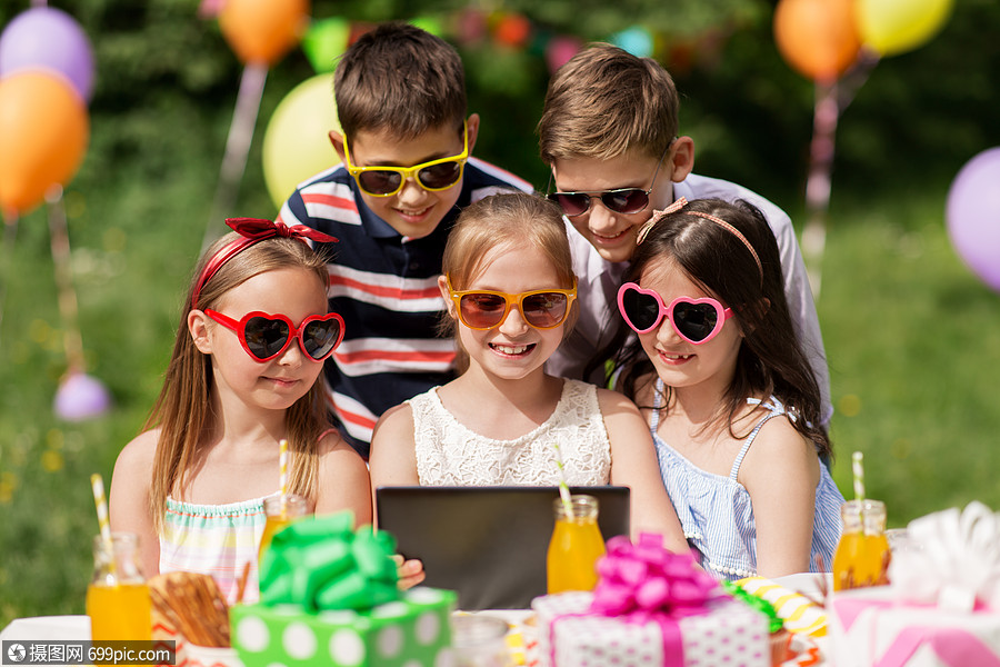 假期童技术快乐的孩子戴太阳镜与平板电脑生日聚会夏季花园生日派上