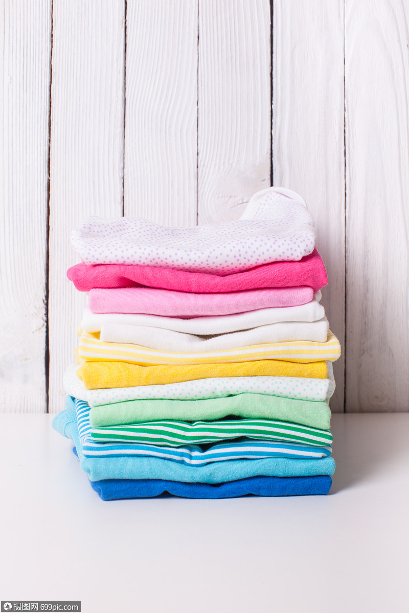 白色背景上折叠成堆的五颜六色的婴儿衣服折叠的婴儿衣服
