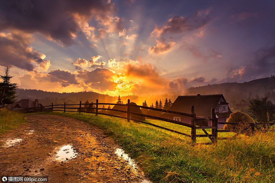 日落雨后美丽多彩的夜晚夏天阳光下的暴风雨云高山景色与所房子个山谷