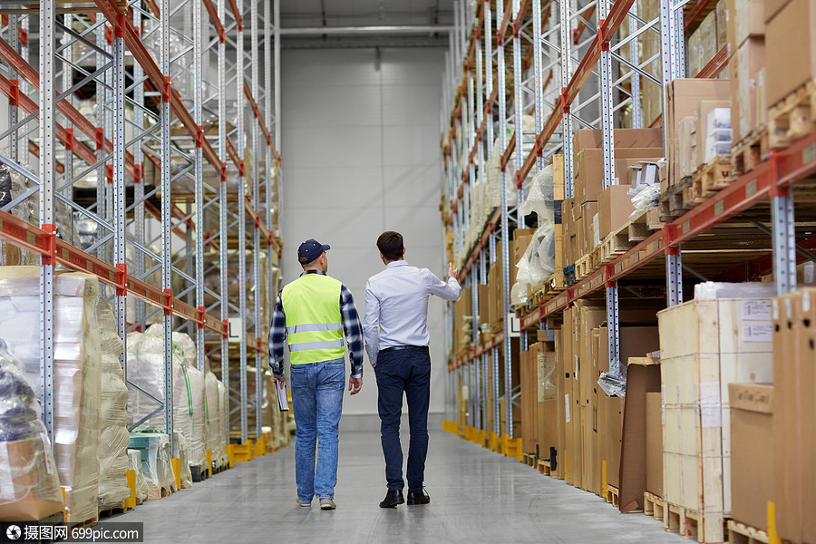 物流业务装运人员商人工人沿着仓库行走的后视镜商人工人沿着仓库走
