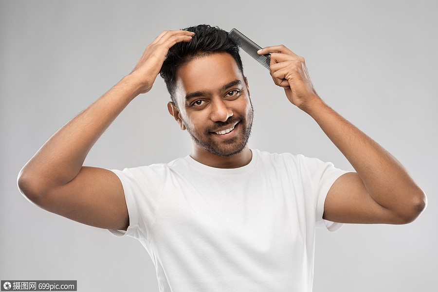 美容发型人的微笑的轻印度男子刷头发与梳子快乐的印度男人用梳子刷