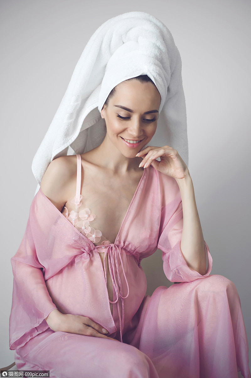 洗澡后穿着粉红色睡衣的美丽孕妇的生活方式肖像美好的早晨美丽健康