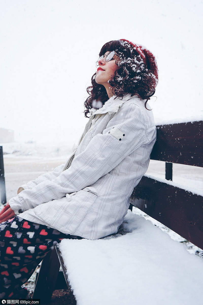 轻漂亮的女人享受着下雪的冬日