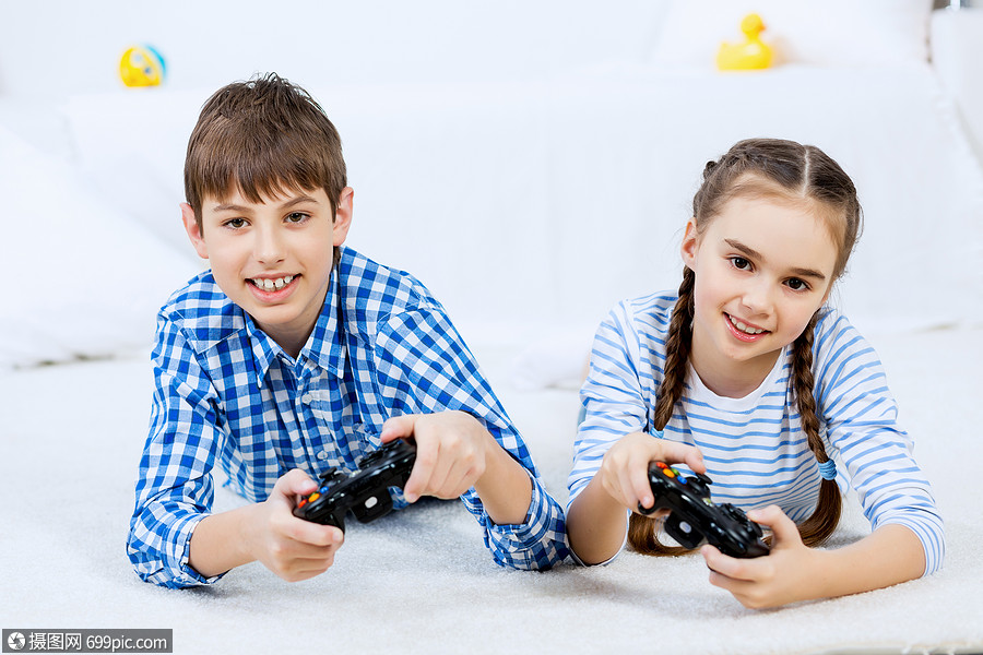 孩子们玩游戏控制台可爱的孩子躺地上,操纵杆上玩游戏小孩乐趣