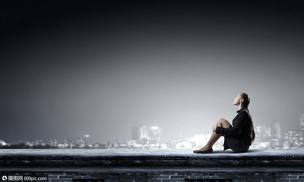 她处于困境孤立之中无聊的轻女商人独自坐屋顶上疲倦的孤独的